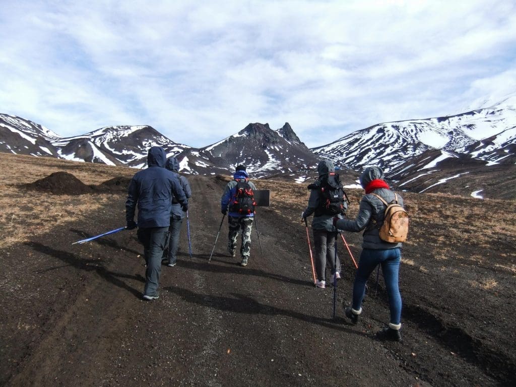 Hikers trekking toward snow-capped peaks near Mount Shkhara, Georgia