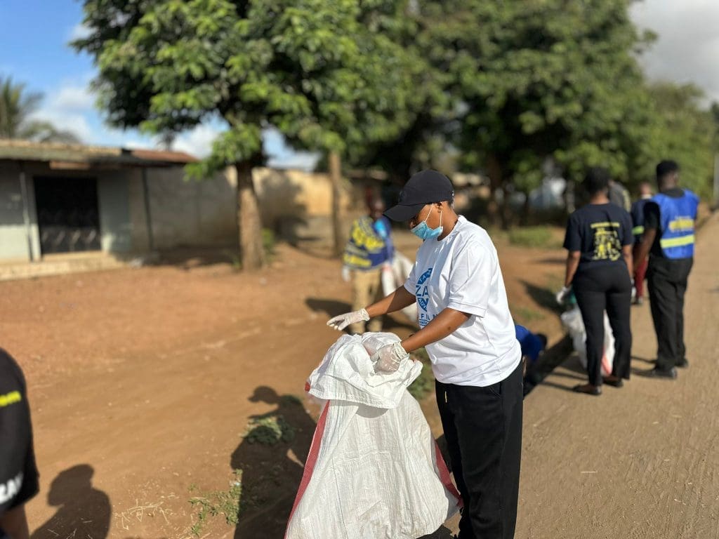 A Zara Tanzania Adventures staff member collects litter during a community clean-up in Moshi to promote the “Green Tanzania Starts with Us” campaign.