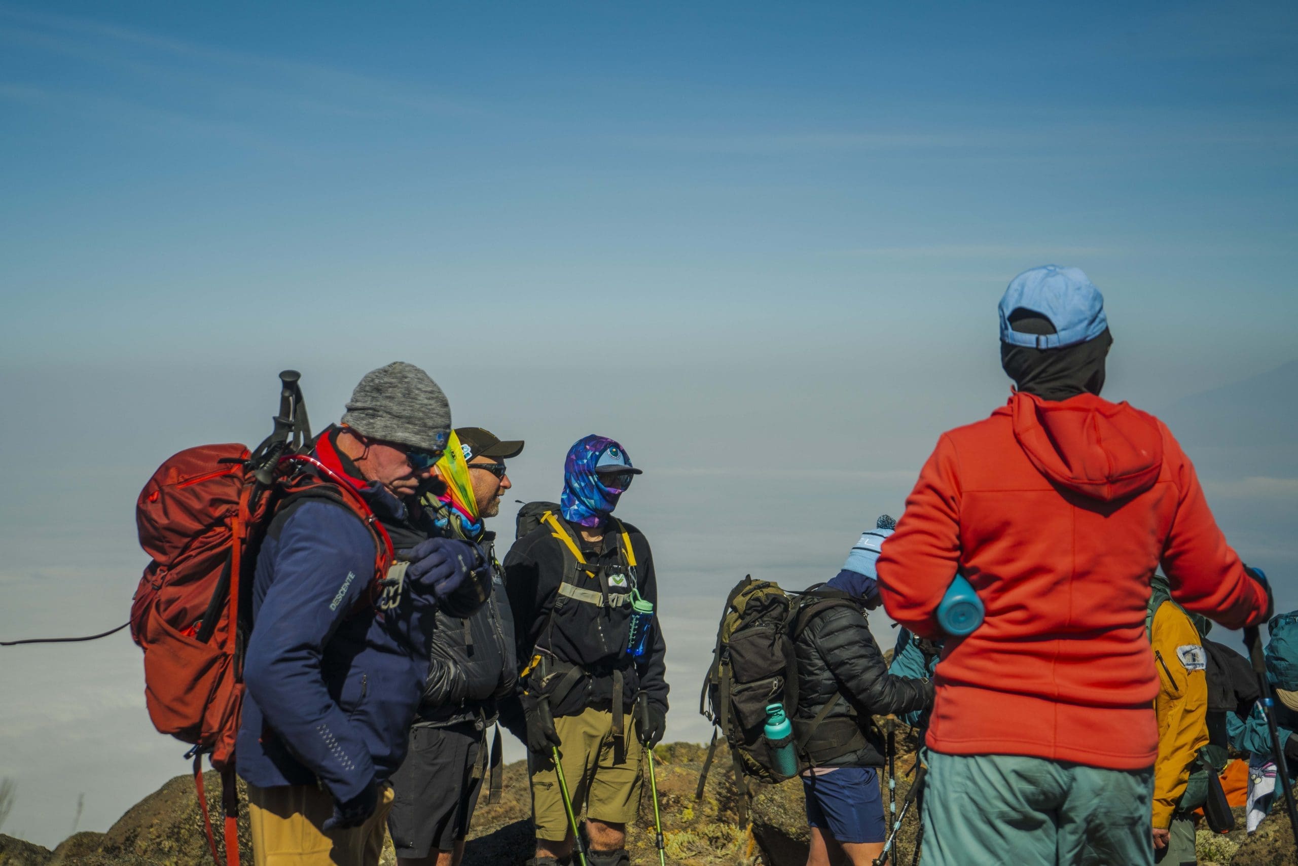 Climbers with their guide resting above the clouds on the Lemosho Route of Mount Kilimanjaro during acclimatization.